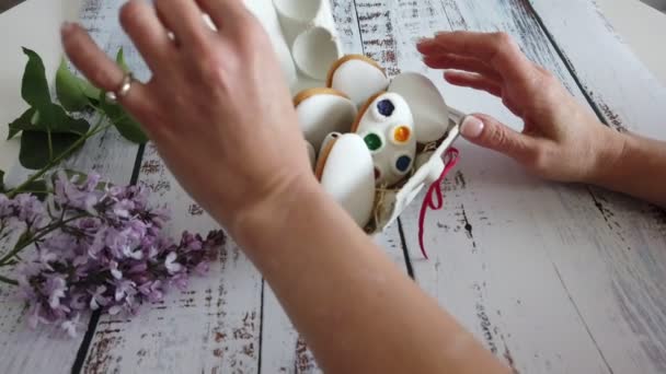 Руки білих відкривають коробку з прикрасою пряників барвистим печивом на дерев'яному фоні — стокове відео