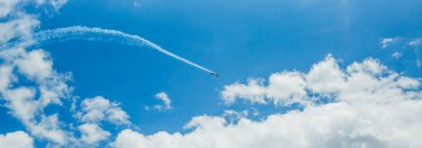 Mavi gökyüzünde akrobasi takım buhar yolları tek bir spor uçak. Düzlem beyaz buhar izleri arka plan izler. Budapeşte, Macaristan.