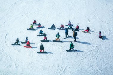 Birçok kayakçı ve snowboardcu kayak merkezinde ki bir yamaçta dinlenir.