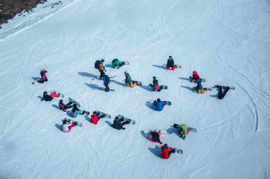 Birçok kayakçı ve snowboardcu kayak merkezinde ki bir yamaçta dinlenir.