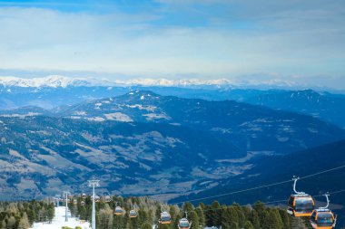 Kışın karlı dağlarda kablo kaldıran turuncu gondol kulübeleri güzel bir arka plan.
