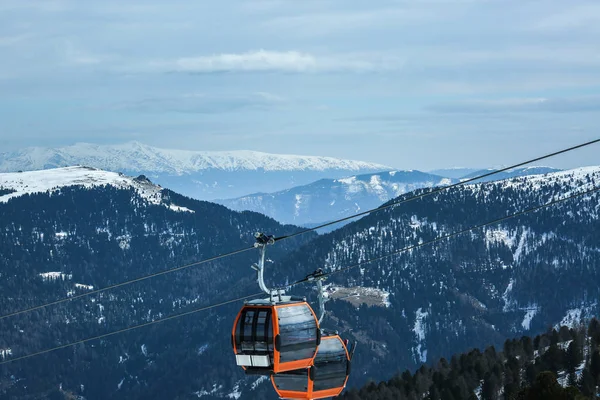 Orangefarbene Gondelkabinen der Seilbahn auf winterlich verschneiten Bergen Hintergrund schöne Landschaft — Stockfoto