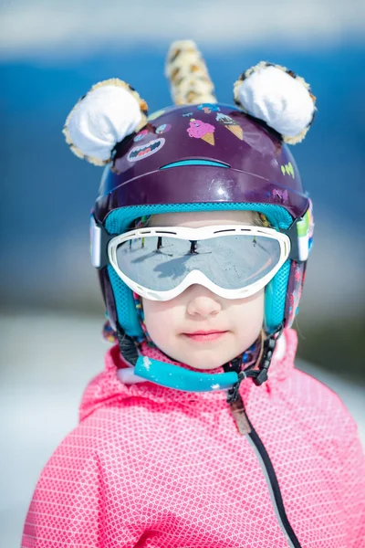 Niña niño con bastones de esquí casco y gafas sonriendo en blanco