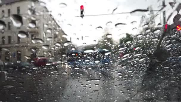 Cadute di pioggia su una finestra che si affaccia su una strada con auto di passaggio — Video Stock