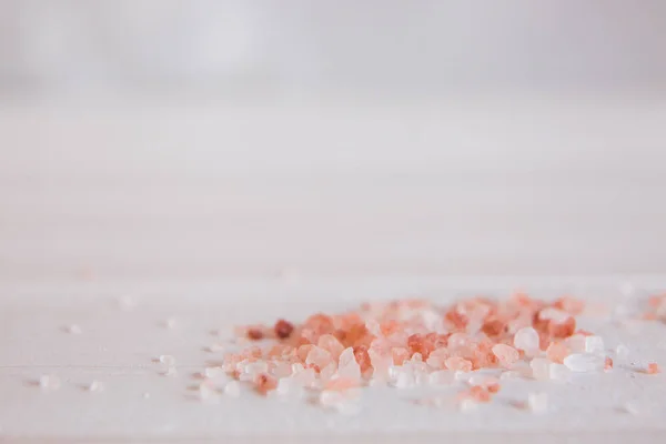 Гималайская соль на белом деревянном столе, макрос — стоковое фото