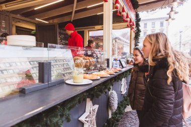 Budapeşte, Macaristan - 19 Aralık 2018: St. Stephens Bazilikası'nın önündeki St. Stephens Meydanı'ndaki güzel Noel Pazarı'nın tadını çıkaran turistler ve yöre halkı.