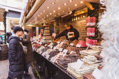 Budapeşte, Macaristan - 19 Aralık 2018: St. Stephens Bazilikası'nın önündeki St. Stephens Meydanı'ndaki güzel Noel Pazarı'nın tadını çıkaran turistler ve yöre halkı.