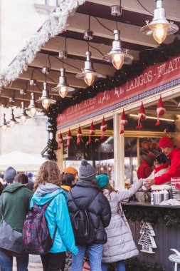 Budapeşte, Macaristan - 19 Aralık 2018: St. Stephens Bazilikası'nın önündeki St. Stephens Meydanı'ndaki güzel Noel Pazarı'nın tadını çıkaran turistler ve yöre halkı.