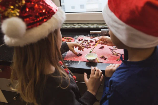 Счастливые дети делают цветные макароны на рождественский ужин — стоковое фото