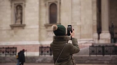 Budapeşte, 26 Ocak 2019 St. Stephen Bazilikası 'nın cep telefonuyla fotoğraf çeken kadın turist. Budapeşte