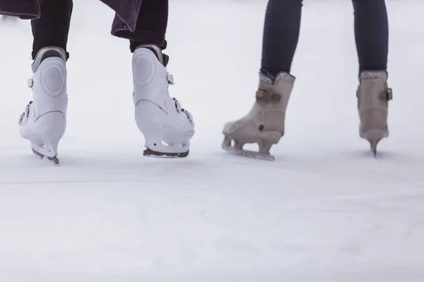 Primer plano de las piernas de las mujeres en los patines en invierno en una pista de patinaje abierto, lugar para el texto — Foto de Stock