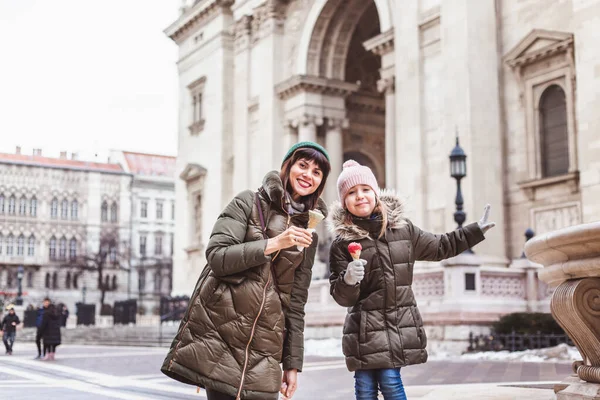 Family eats ice cream rose near St. Stephen Basilica. Famous place in Budapest