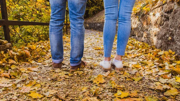 Žena a muž boty na suchém podzimním listí v přírodním parku venkovní a podzimní sezóně — Stock fotografie