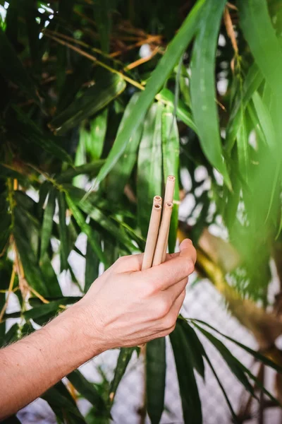 Bambú reutilizable bebiendo paja en las manos del hombre sobre fondo de bambú. Concepto de cero residuos —  Fotos de Stock
