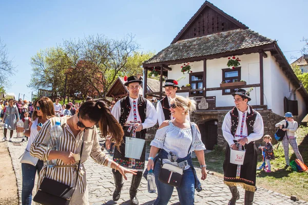 HOLLOKO, HUNGRÍA - 12 de abril de 2019: Festival de Pascua en el pueblo folclórico de Holloko en Hungría. Chicos espolvorear agua en las niñas — Foto de Stock