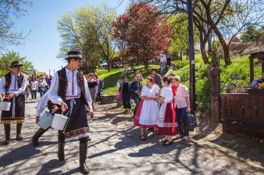 HOLLOKO, HUNGARY - 12 Nisan 2019: Macaristan 'ın Holloko kasabasında Paskalya festivali. Erkekler kızların üzerine su serper.