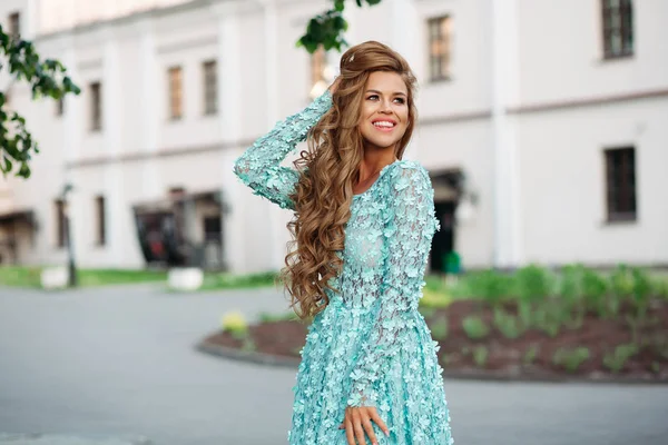 Шикарная и красивая девушка в цветущих голубых платьях улыбается . — стоковое фото