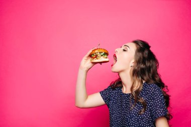 Açılan ağzı büyük hamburger yeme aç kız.