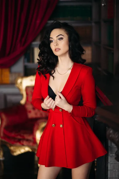 Σέξι κορίτσι με κόκκινο φόρεμα undresiing αγγίζοντας το στήθος της και γδύσιμο. — Φωτογραφία Αρχείου