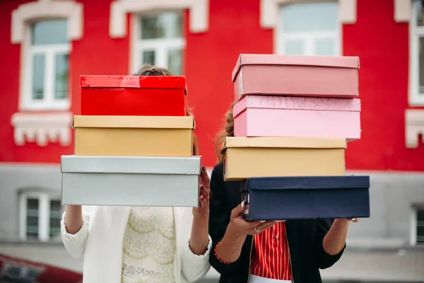 Onherkenbaar vrouwen met dozen van schoenen in de straat. — Stockfoto