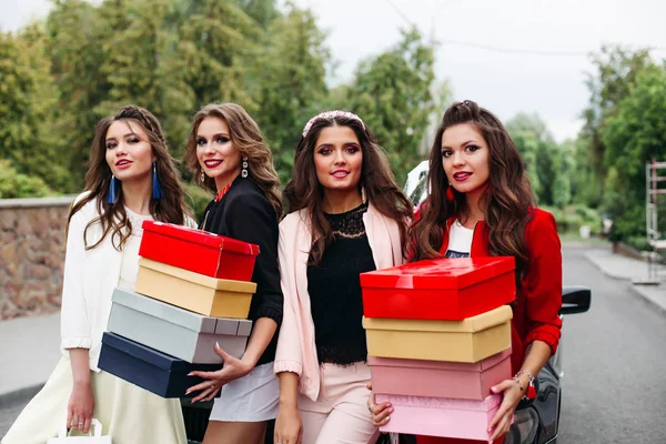 Quatre copines à la mode avec des boîtes à chaussures dans la rue . — Photo