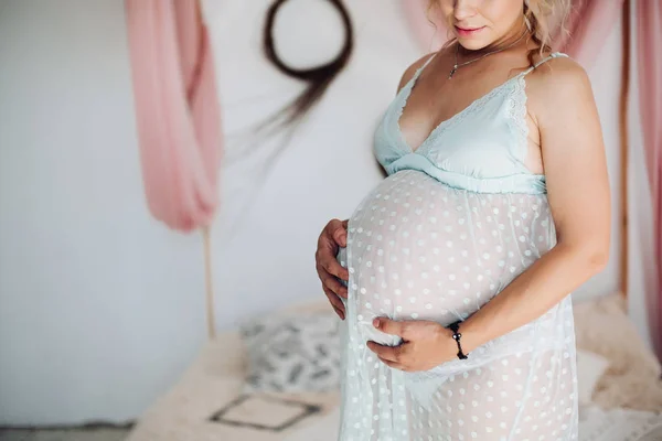 Mulher grávida irreconhecível em lindo vestido de noite de renda azul em casa . — Fotografia de Stock