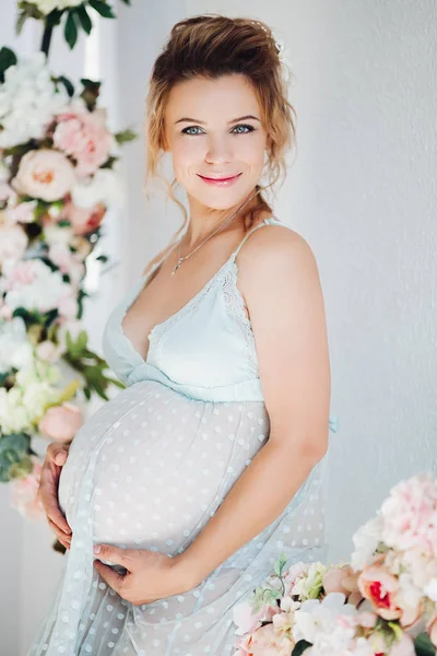 Чуттєвість вагітна в сукні в нижній білизні прикрашає живіт і посміхається . — стокове фото