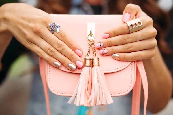Odzież piękny ręce z modny manicure trzyma śliczny brzoskwiniowy crossbag. — Zdjęcie stockowe
