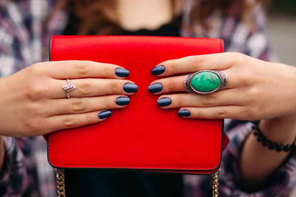 Onherkenbaar vrouw met donker nagels houden rode handtas. — Stockfoto