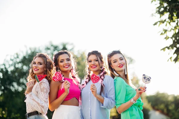 Gruppo di ragazze alla moda con cuori di caramelle su bastone . — Foto Stock