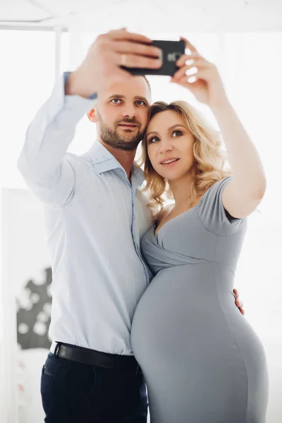 Paar knappe man en zwangere vrouw nemen zelfportret. — Stockfoto