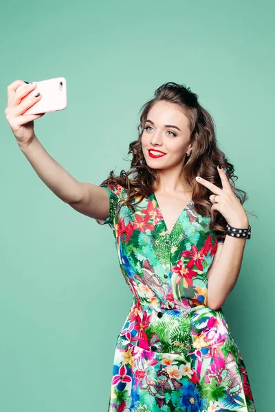 Fashionable woman showing peace and taking photo of herself.