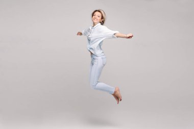 Pozitifliği ve şık kıyafet kadar atlama içinde mutlu güzel sarışın kız görünümünü.