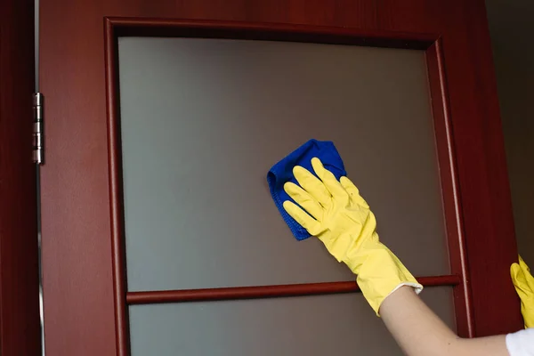 Cultivo de manos de ama de casa con guantes amarillos, limpieza de la ventana sucia . — Foto de Stock