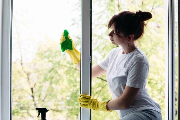 Morena ama de casa limpieza ventana sucia grande. Concepto de tareas domésticas y servicio de apartamentos . — Foto de Stock