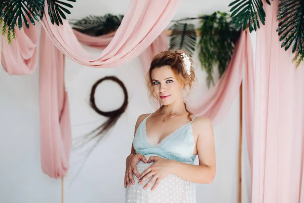 Hermosa mujer embarazada sensual en vestido de noche en dormitorio decorado . — Foto de Stock