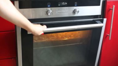 Kadın fırın mutfak at açılış ve pizza veya güveç ızgara kapat.