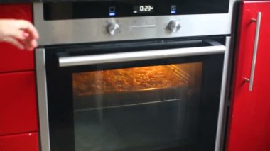 Kadın fırın mutfak at açılış ve pizza veya güveç ızgara kapat.