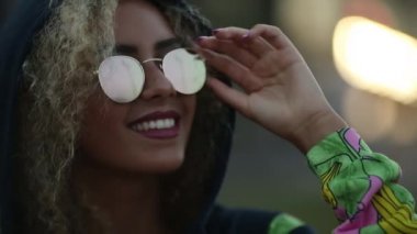 Hippi kız hoodie ve rahatlatıcı ve gülümseyen güneş gözlüğü giyiyor.
