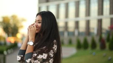 Uzun saçlı konuşmak çağrı telefon günbatımında moda esmer kadın.