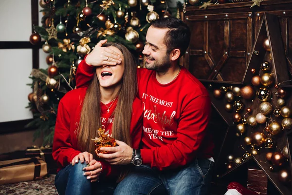 Hombre feliz cubriendo los ojos de sus novias en Navidad . — Foto de Stock