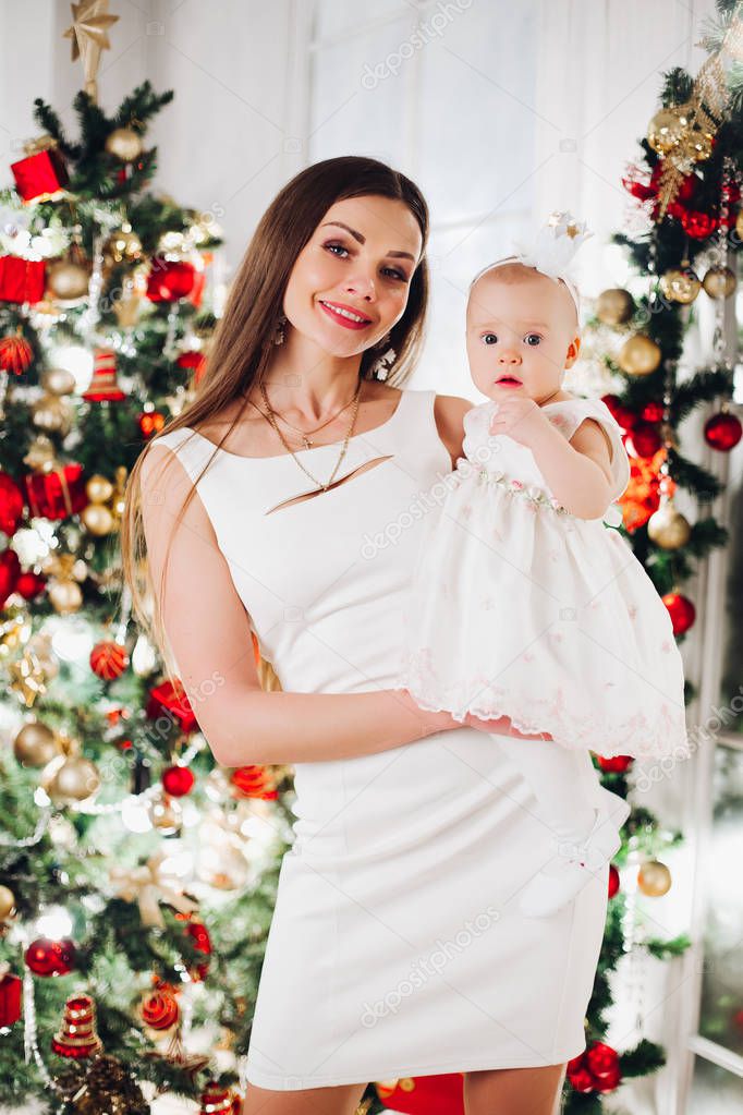 Beautiful woman in white dress with lovely little baby girl.