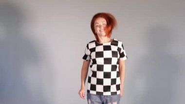 Dans ve atlama Studio'da deseni elbiseli güzel mutlu kırmızı saçlı kız.