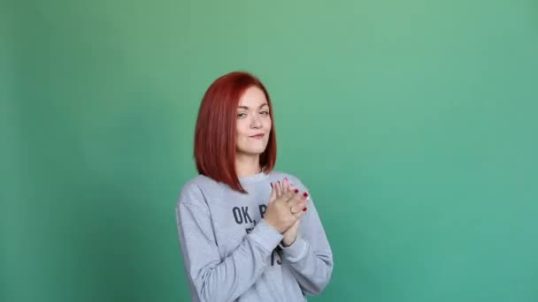 Hübsches Mädchen mit einer Botschaft auf ihrem Trikot vor grünem Hintergrund. — Stockvideo