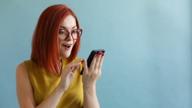 Zencefil kız gözlük ve smartphone tarama ve sürpriz gösterilen sarı top.