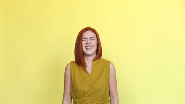 Emocional chica con el pelo rojo gritando sobre fondo amarillo . — Vídeos de Stock