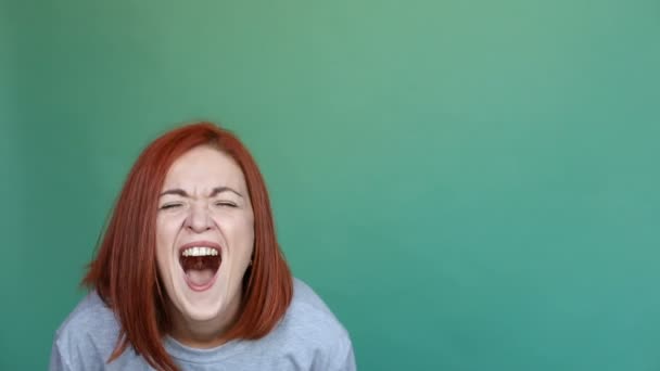 Mujer en jersey llorando y gritando sobre fondo liso y verde . — Vídeos de Stock