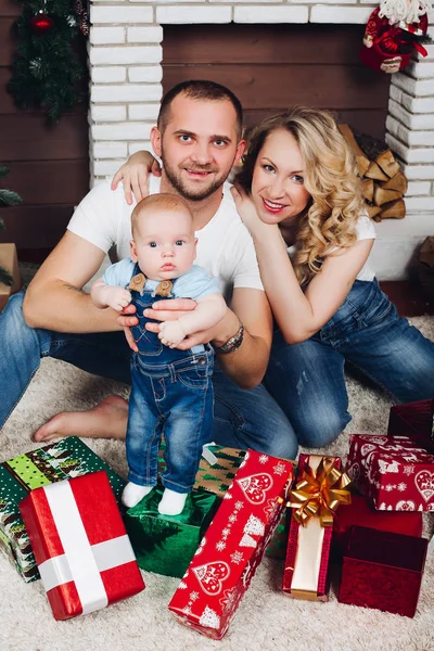 Família positiva posando junto perto da lareira e presentes para o Natal — Fotografia de Stock