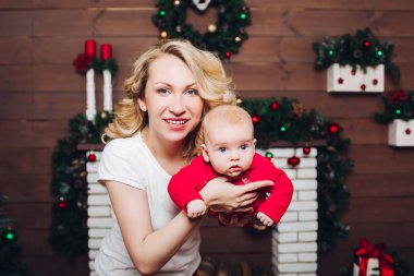 Noel için dekore edilmiş Studio'da kucaklayan güzel sarışın anne çocukla.