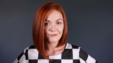 Kameraya bakarak merakla şık Kızıl saçlı kadın.